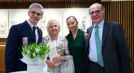 Four people stand for picture taken, smiling