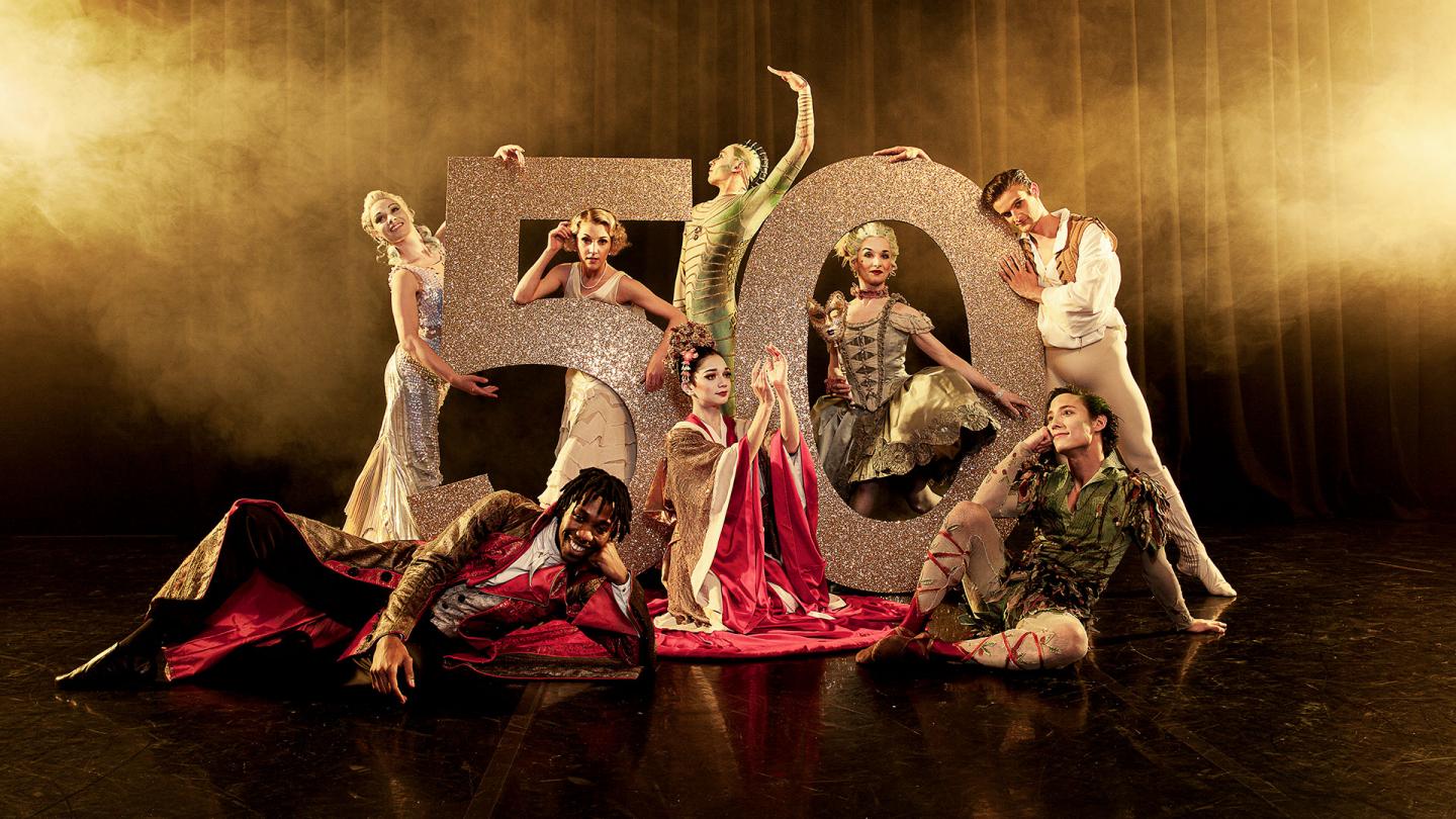 Northern Ballet dancers posing in front of a large number 50 wearing costumes of different productions. Photo Guy Farrow.