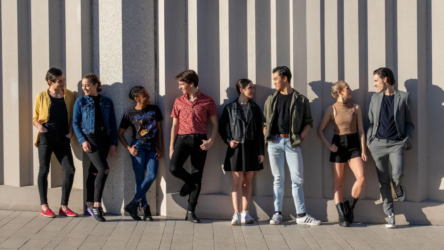 4 pairs of dancers stand against a wall