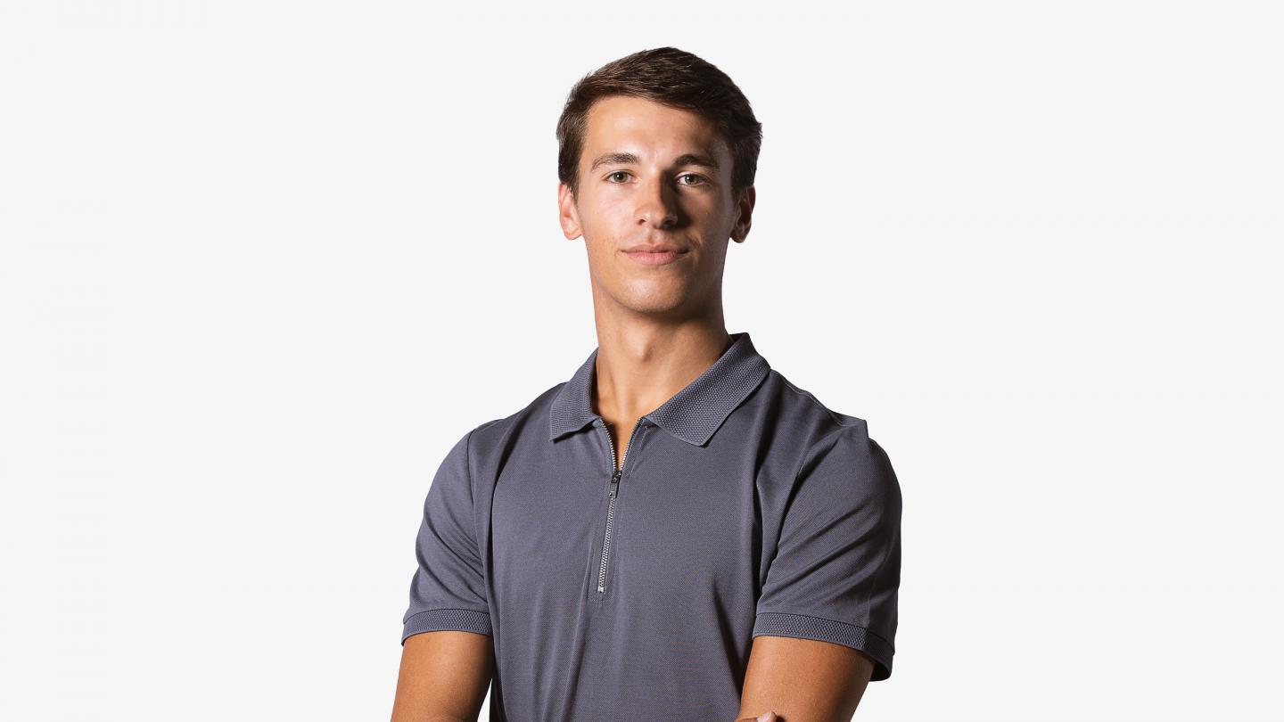 Headshot of a male dancer in a navy polo shirt