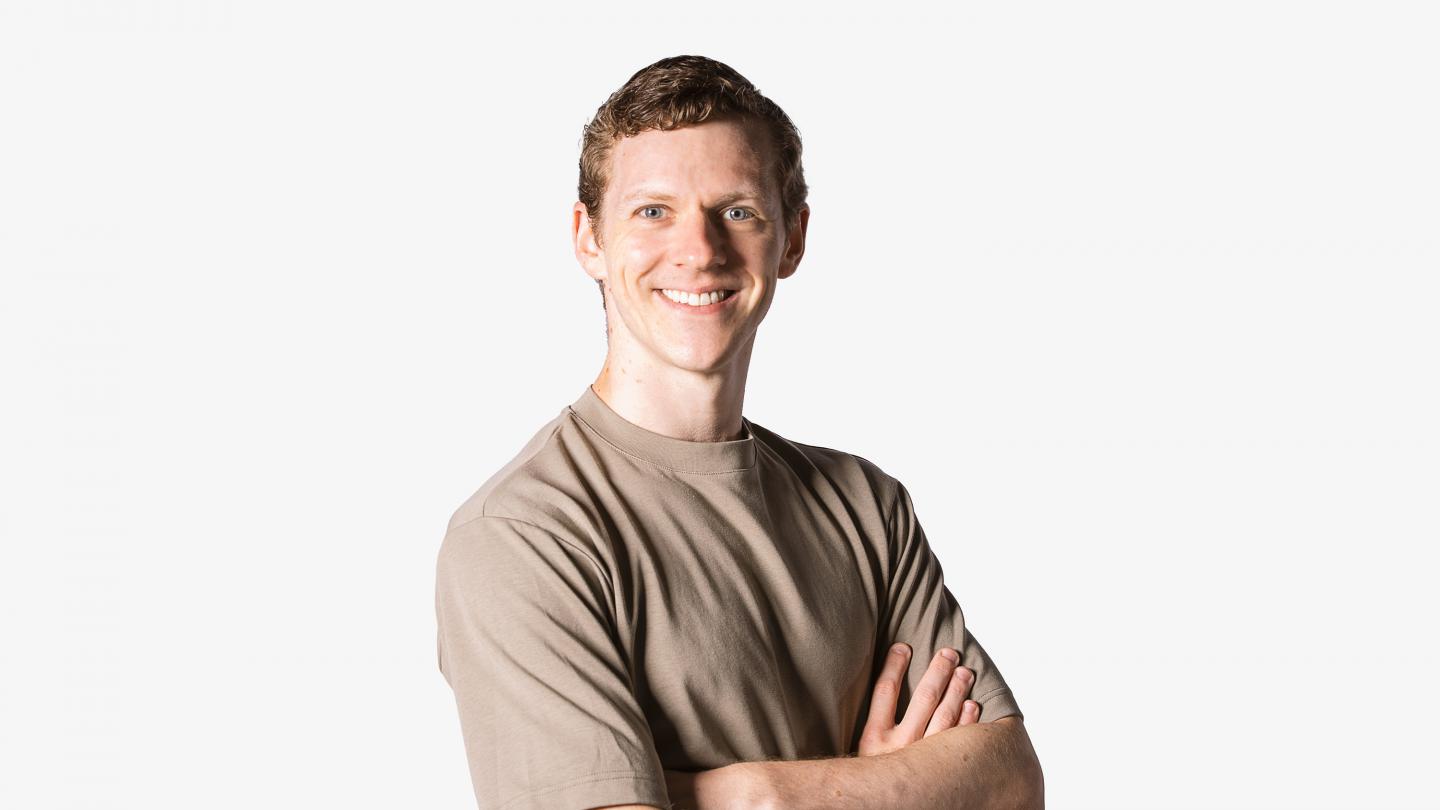 Headshot of a male dancer in a brown shirt