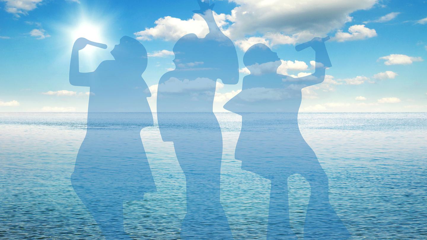 A silhouette of three people against a background of an ocean vista under an azure sky