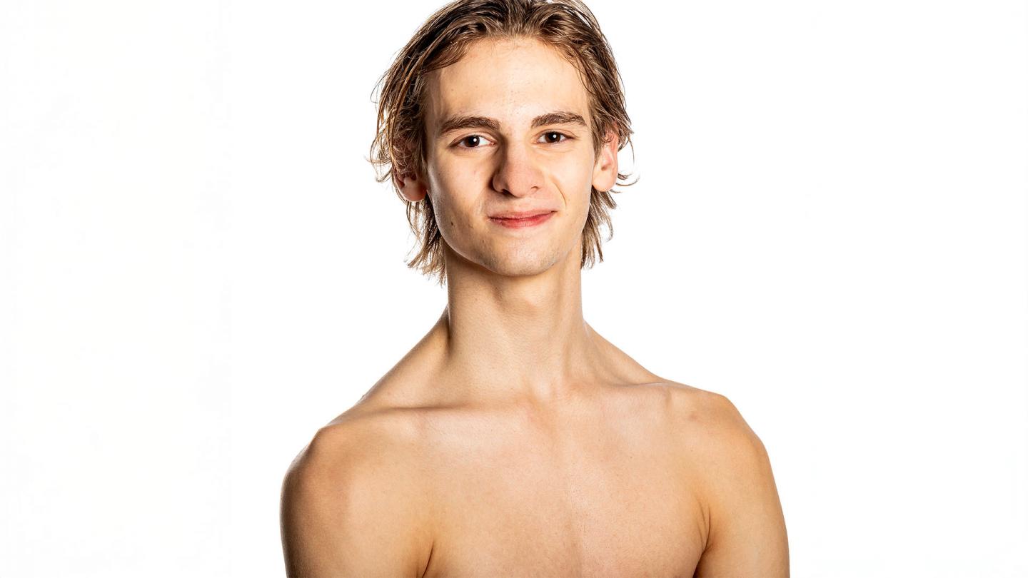 Top of male body and smiling face, medium length, wet, blond/brown hair