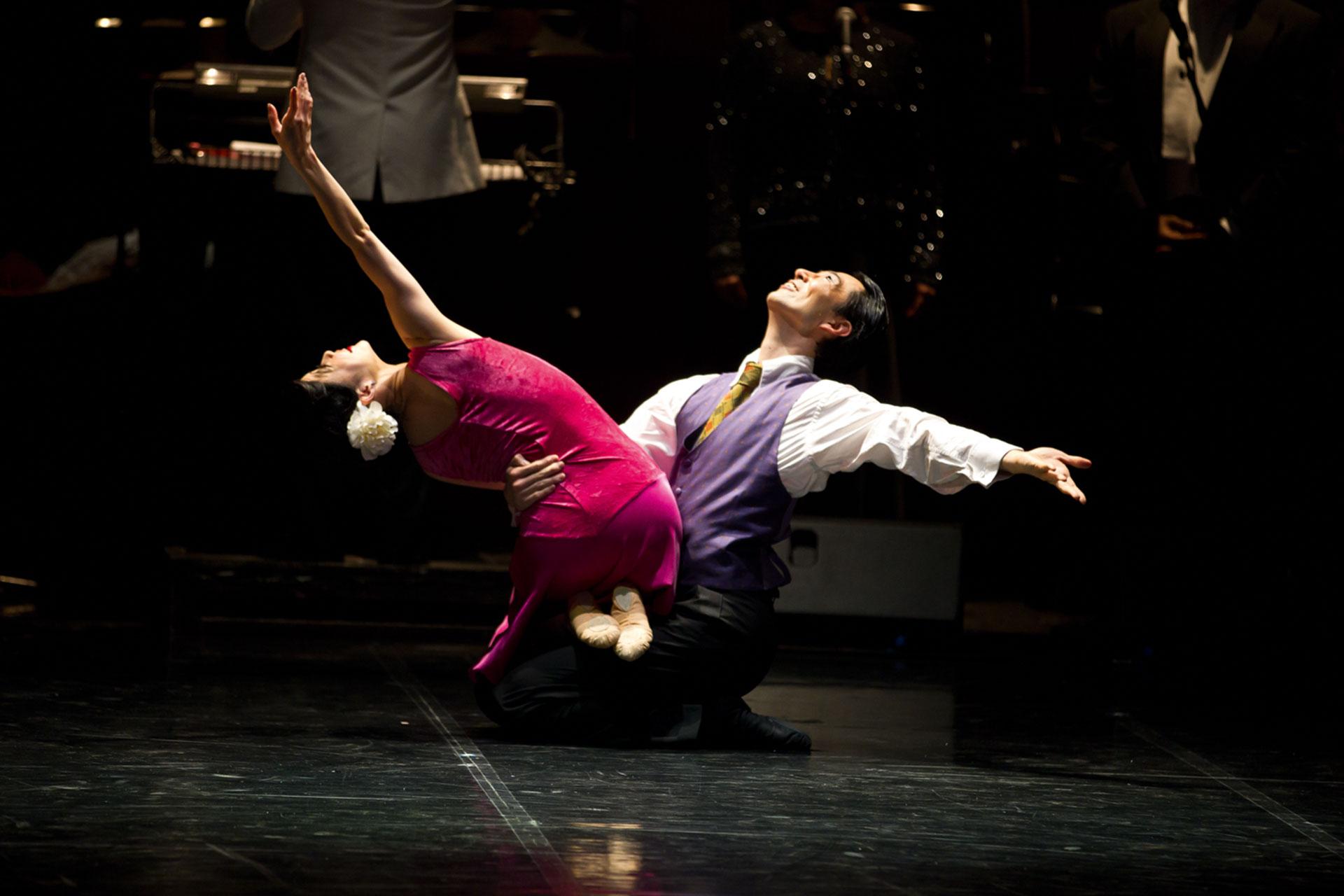 I Got Rhythm, production, 2012, Ayana Kanda and Hironao Takahashi, photo Emma Kauldhar Ayana Kanda and Hironao Takahashi lean back in celebration which holding tight to each other