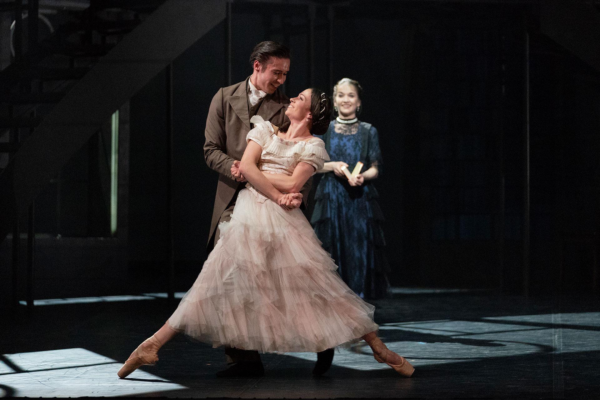 Victoria, production, 2019, Abigail Prudames and Joseph Taylor, photo Emma Kauldhar Beatrice looks on as she reads of Prince Albert and Victoria's love