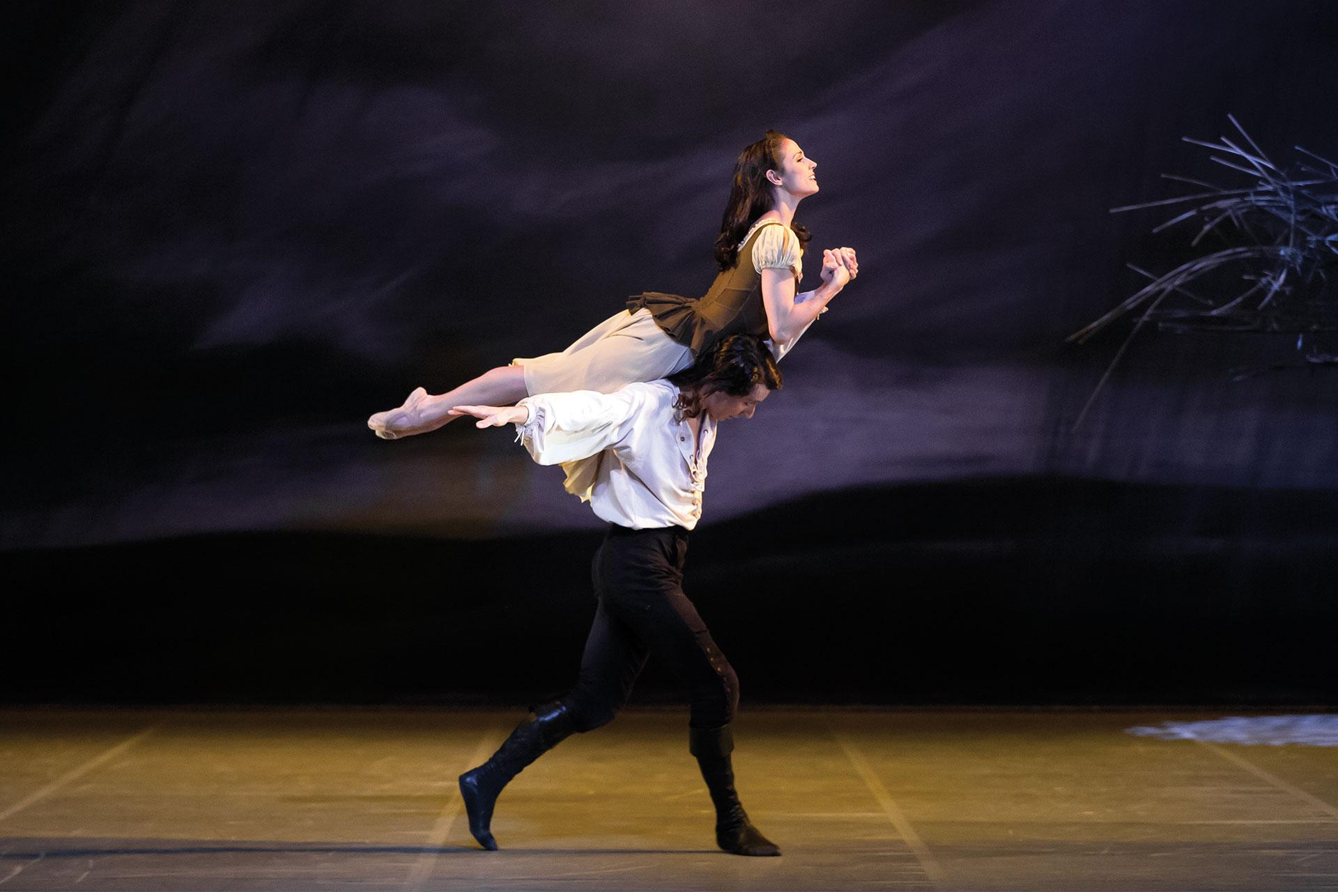 Wuthering Heights, production, 2015, Martha Leebolt as Cathy and Tobias Batley as Heathcliff, photo Emma Kauldhar Heathcliff carries Cathy on his back through their old playing fields on the moors