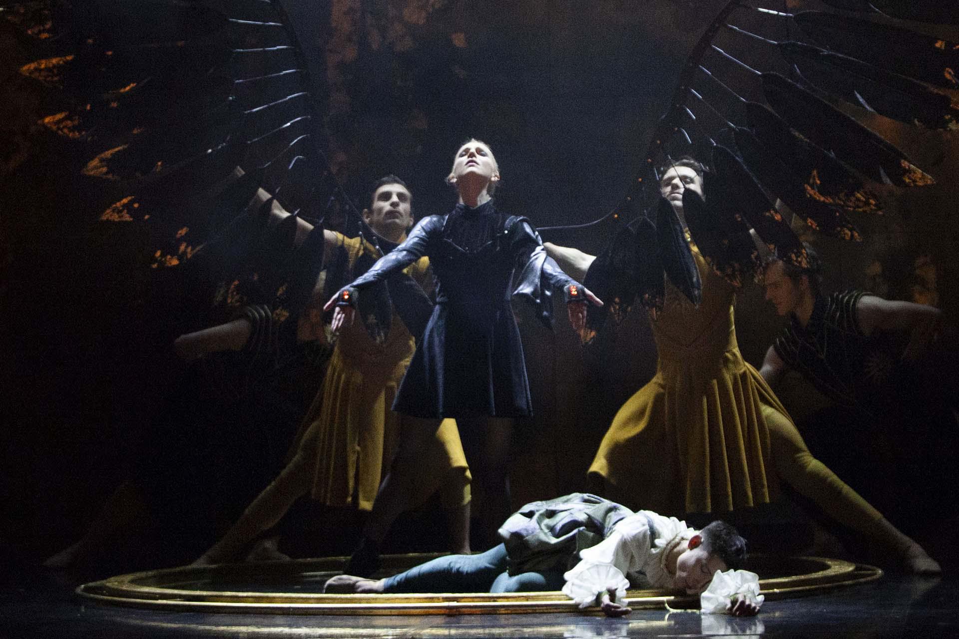 Merlin, production, 2021, Antoinette Brooks-Daw as Morgan. Photo Caroline Holden Morgan stands proudly with her new black wings unfurled while Merlin lies drained at her feet