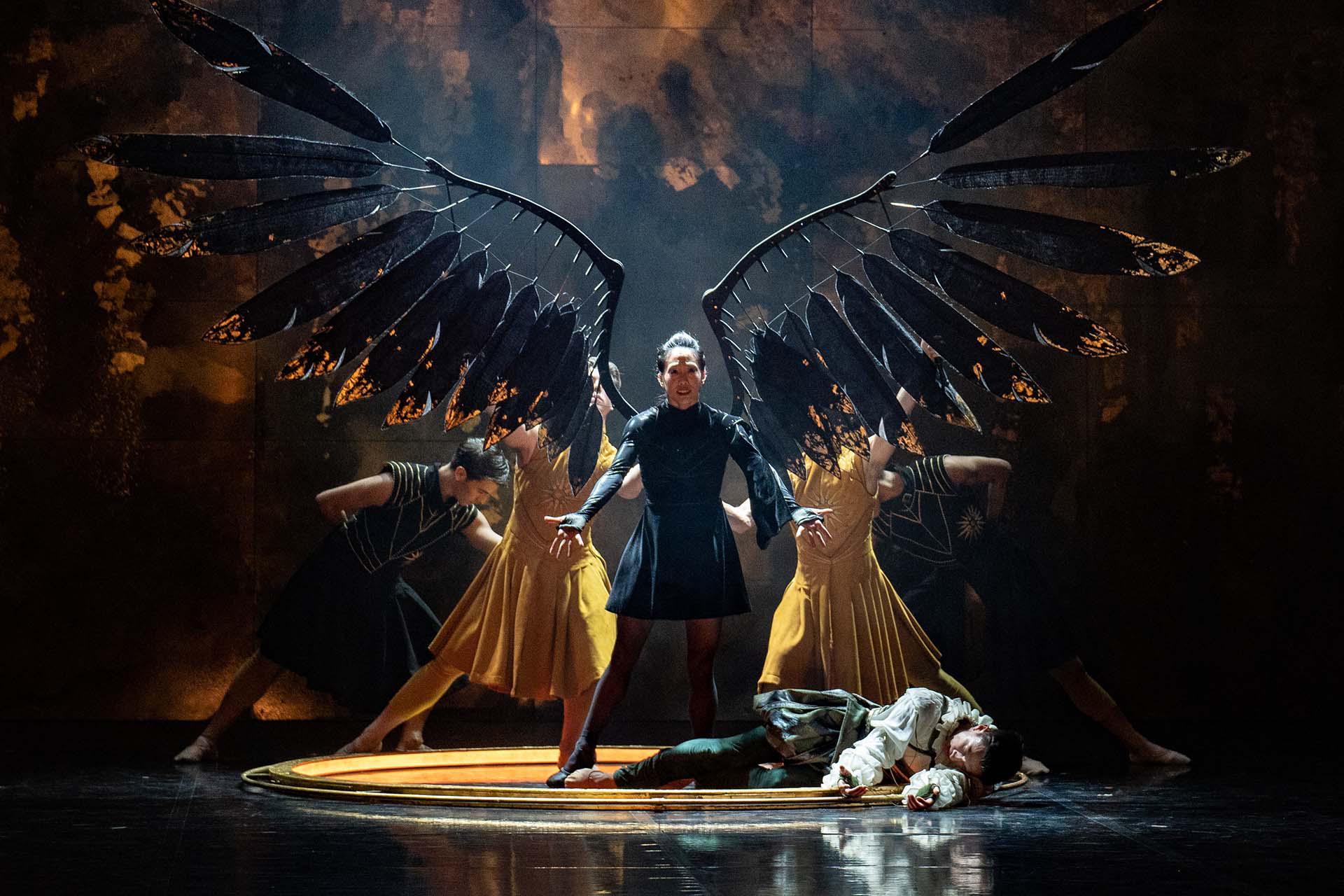 Morgan extend her wings with the power she has stolen from Merlin, lying prone at her feet