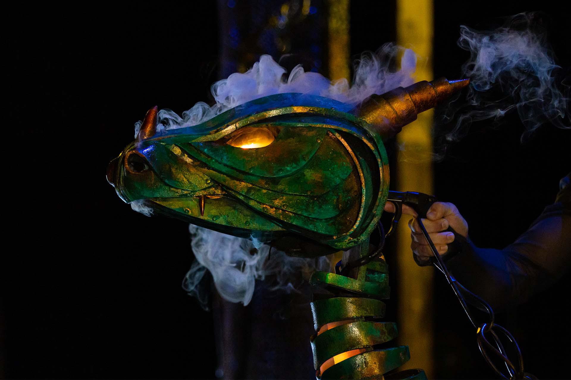 Merlin, production, 2021, The Dragon. Photo Emily Nuttall The Dragon, eyes glowing and smoke pouring from its mouth