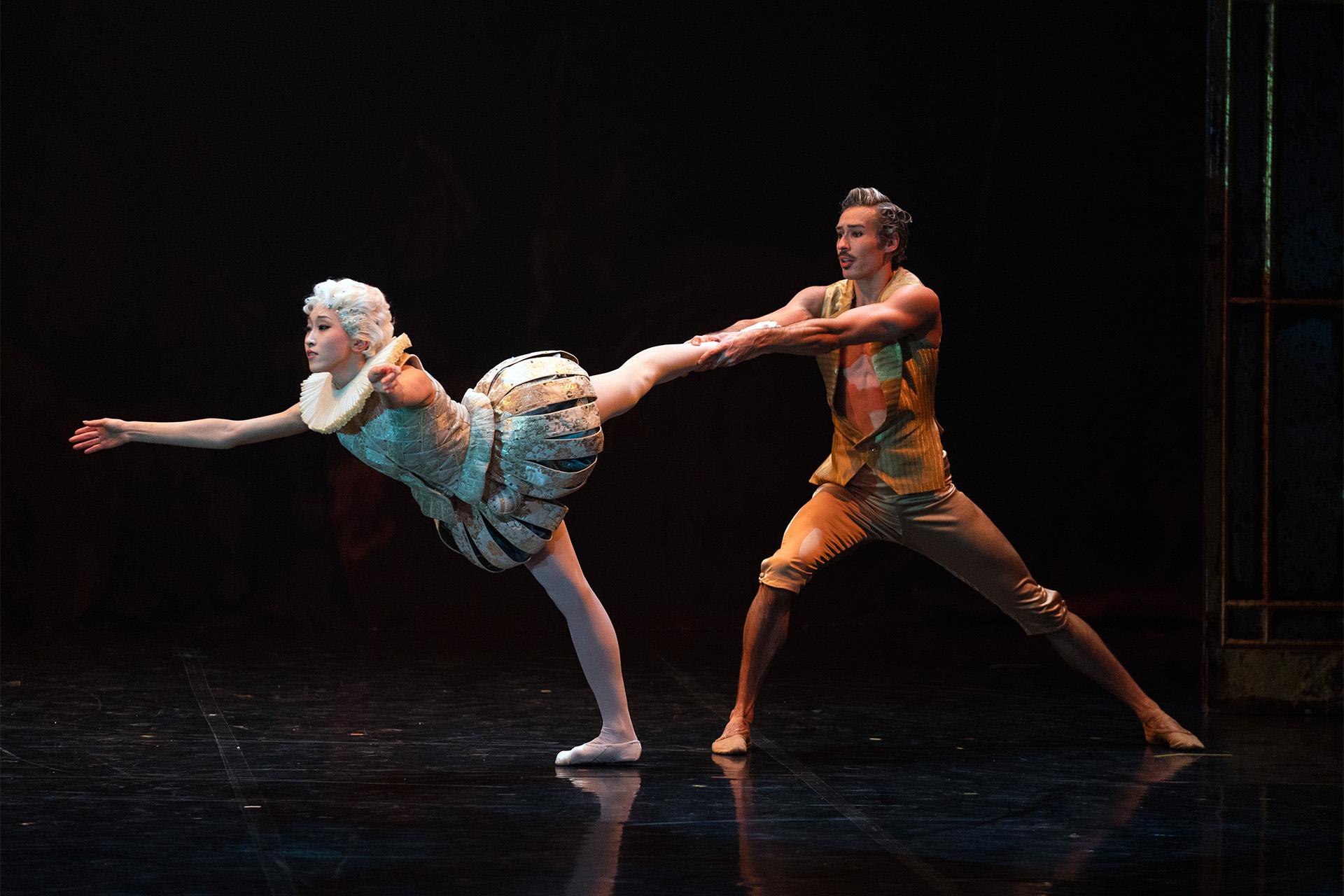 Bellino in her ruff and 18th century costume lean forward but is prevented from falling by Casanova holding her foot