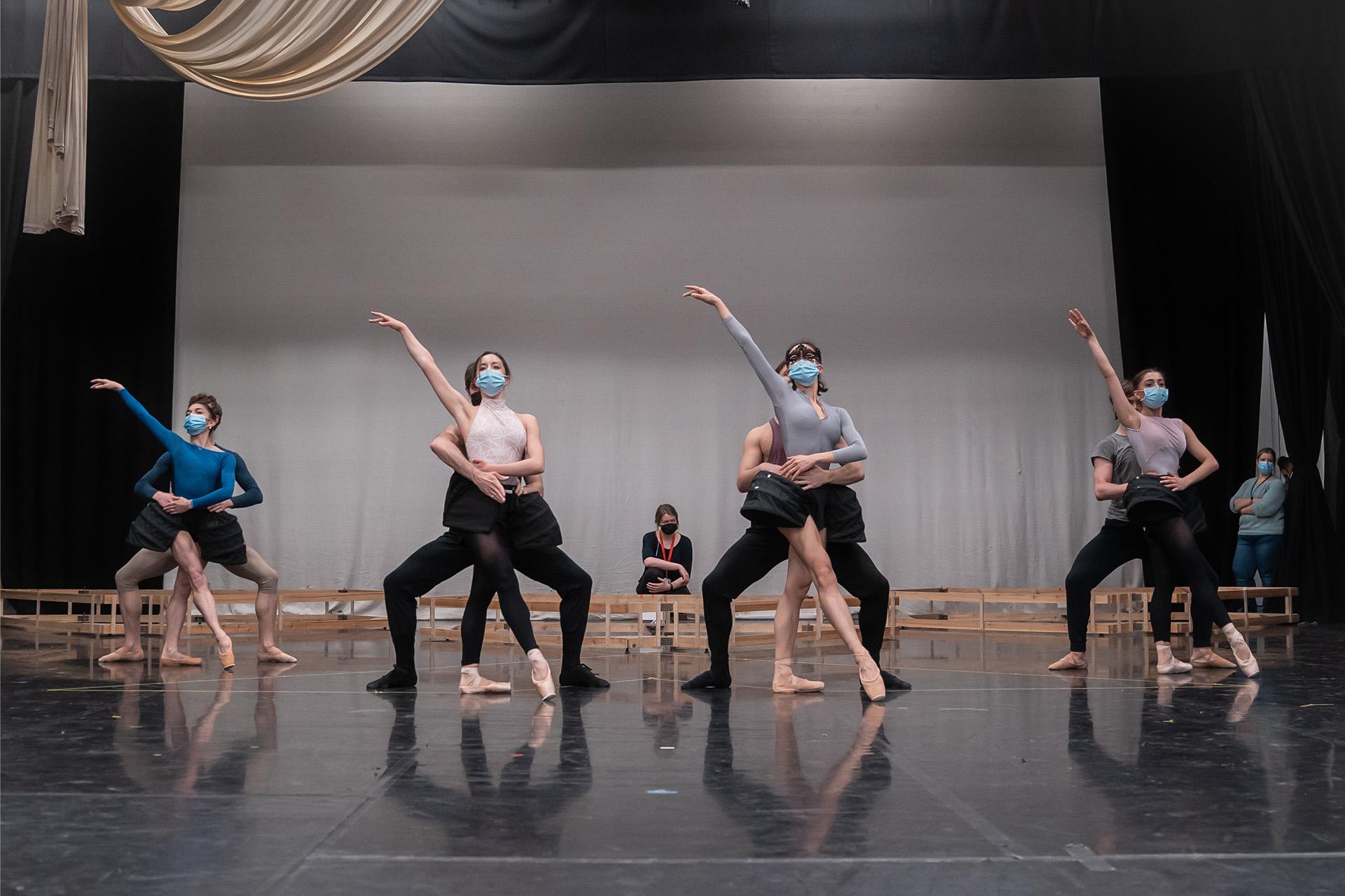 Four pairs of dancers, one partner holding the other from behind