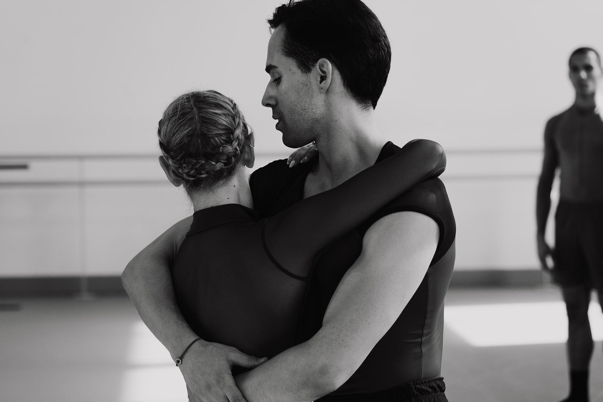 Dancers Harry Skoupas and Harriet Marden both facing away from the camera, arms around one another