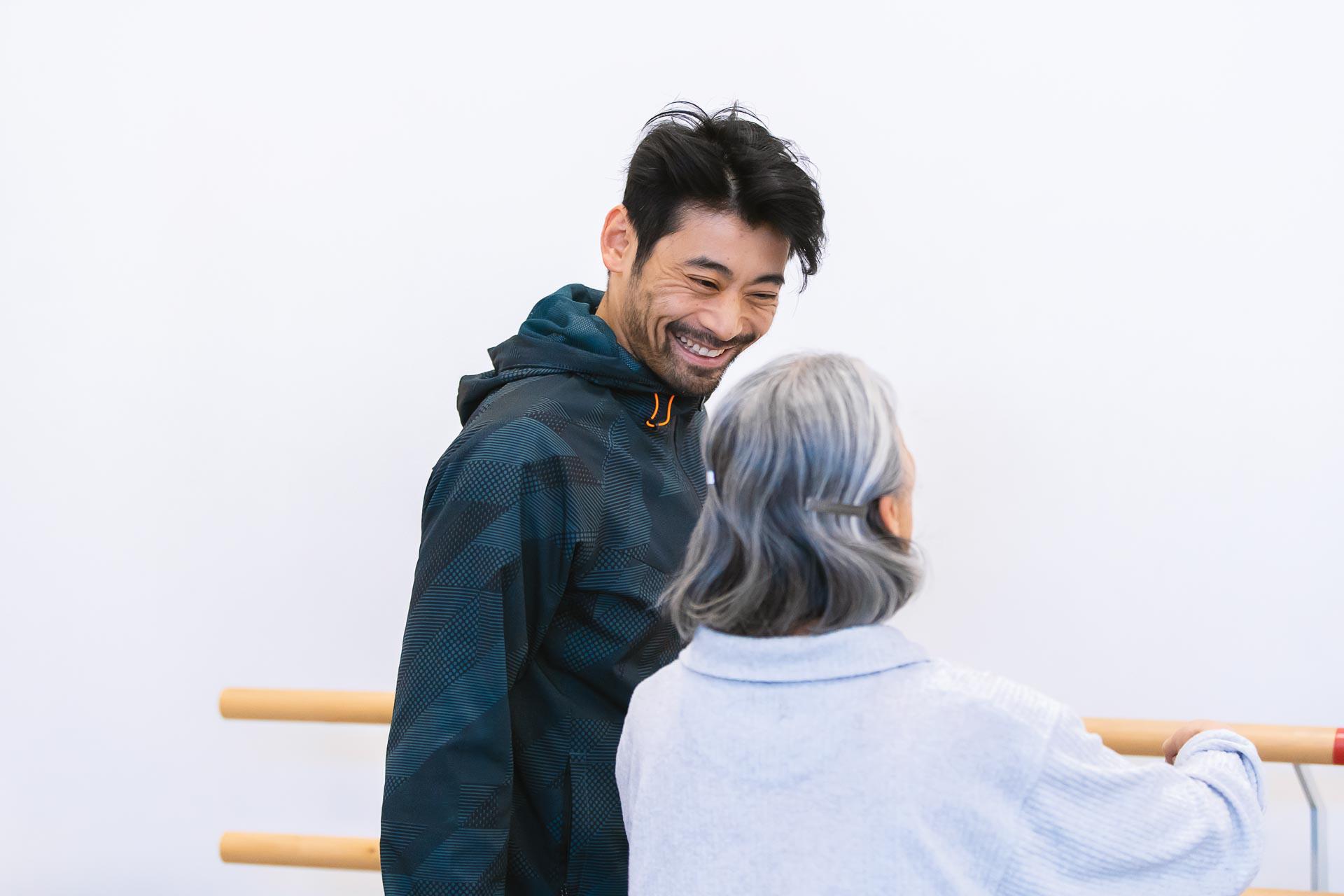 Man and a woman stood by a ballet bar laughing