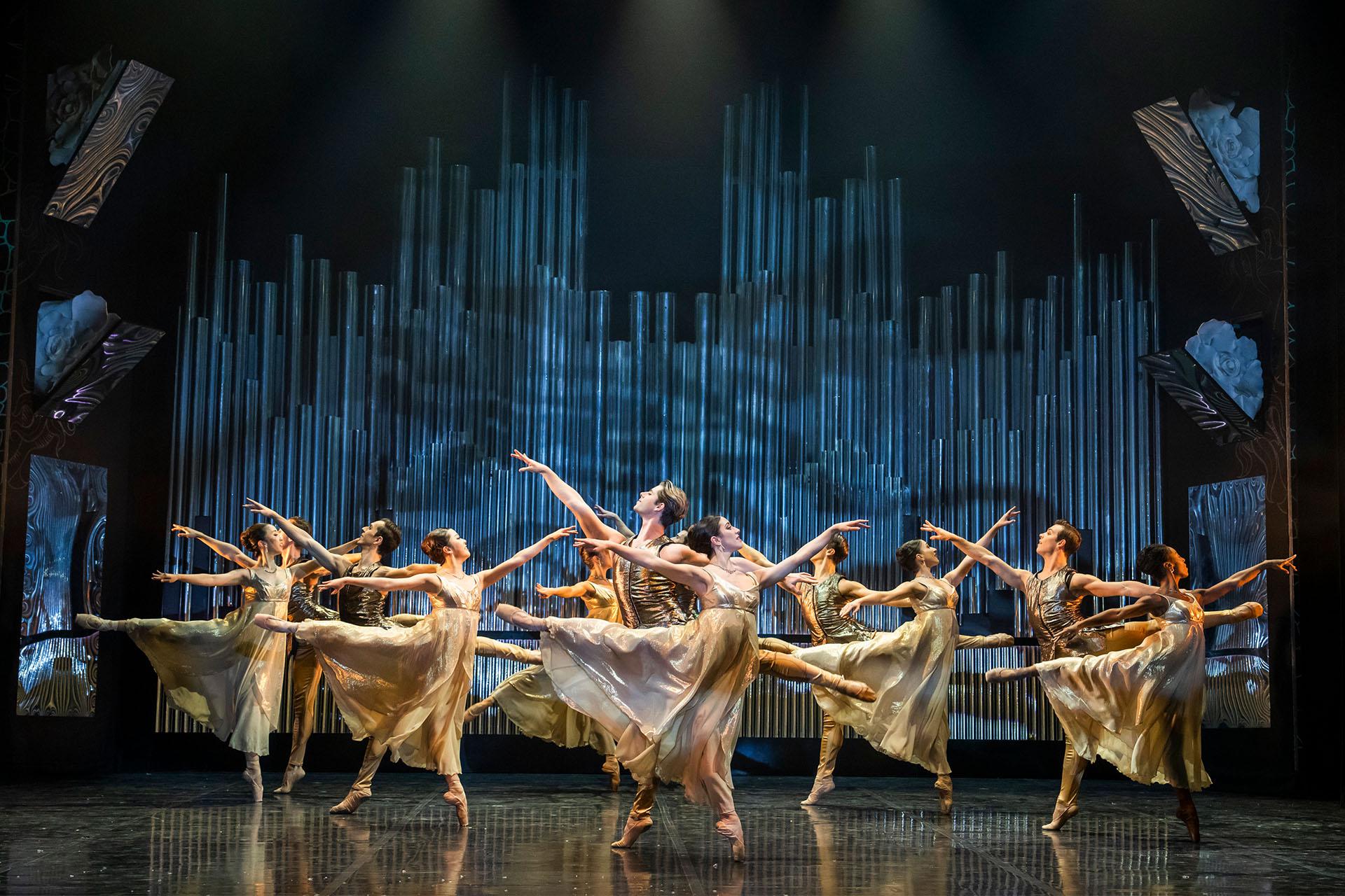 Beauty and the Beast, production, 2023, Northern Ballet dancers, photo Tristram Kenton A dozen dancers in gold and white dance in unison, each stood on one foot, the other leg in arabesque behind them