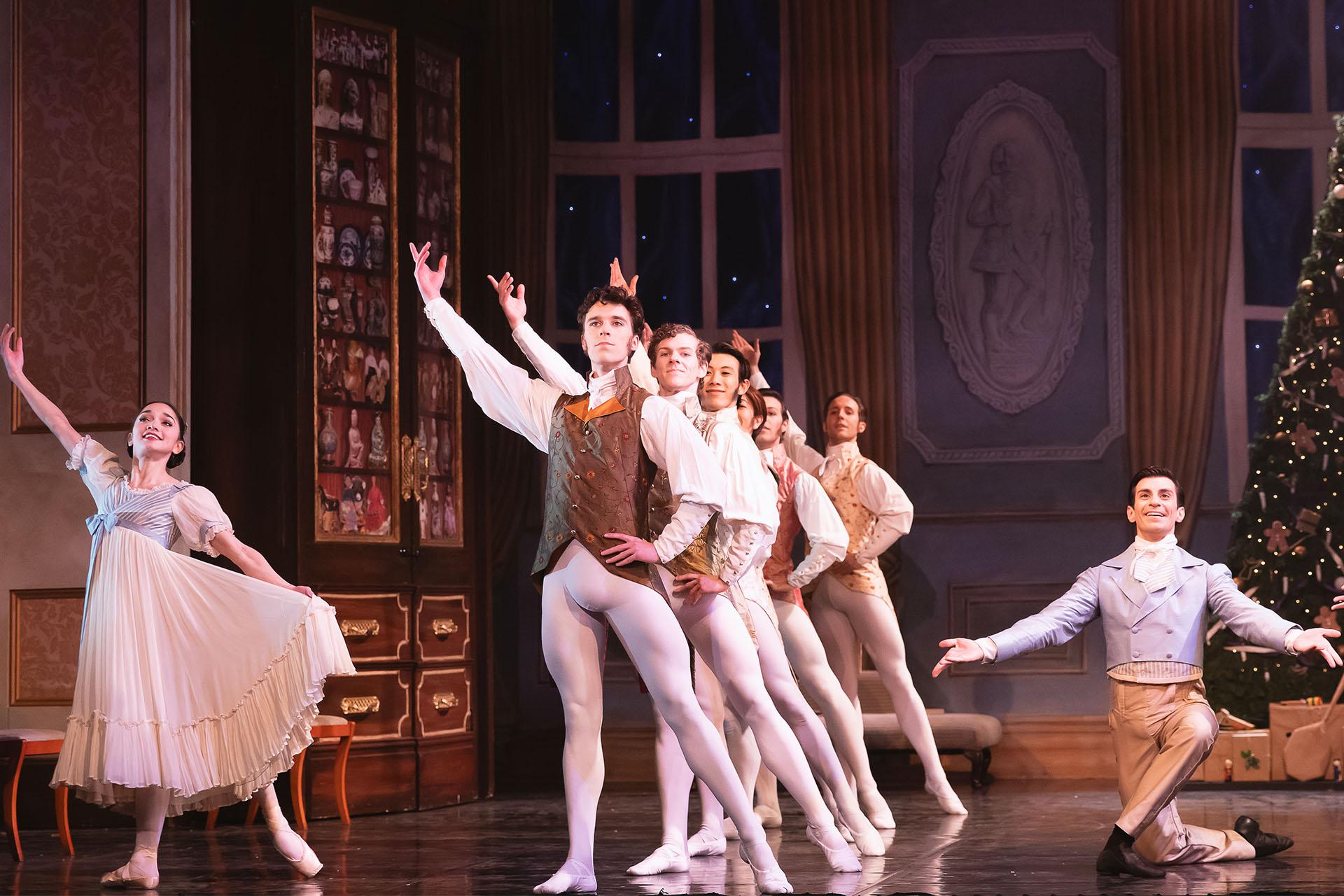Six male dancers pose in front of each other with the same pose