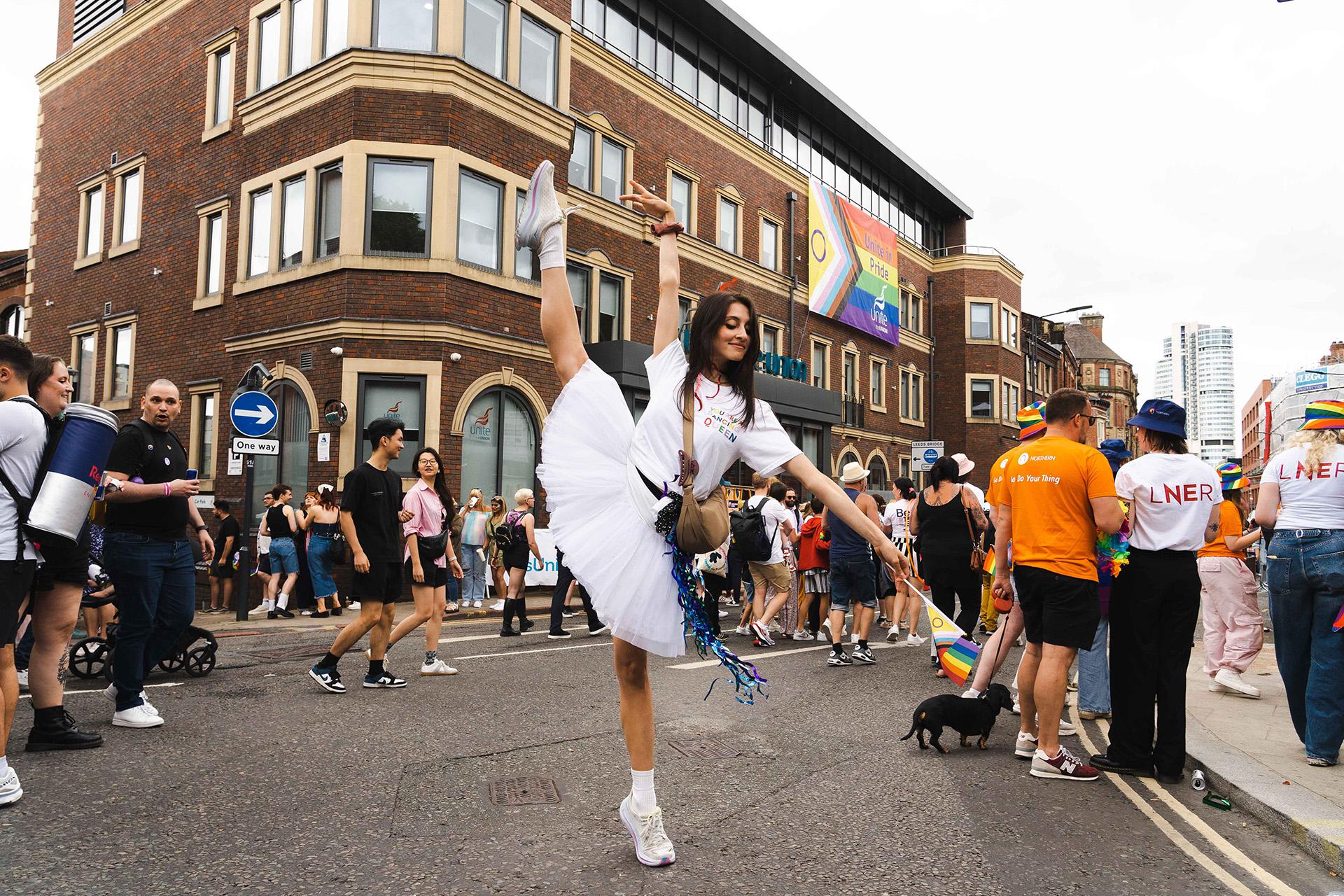 Dancer during the Pride parade in Leeds performs a developpe à la seconde during the march