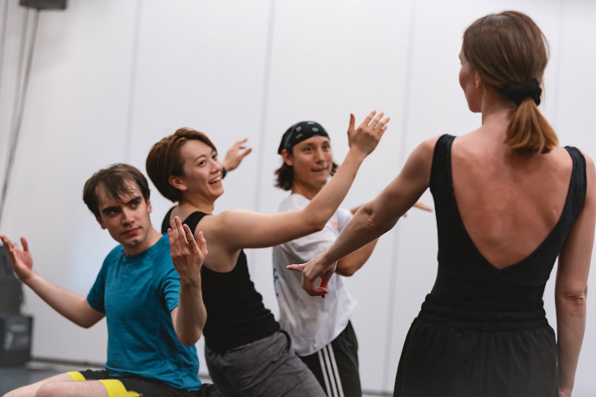 Three smiling dancers looking for approval from the supervising choreographer