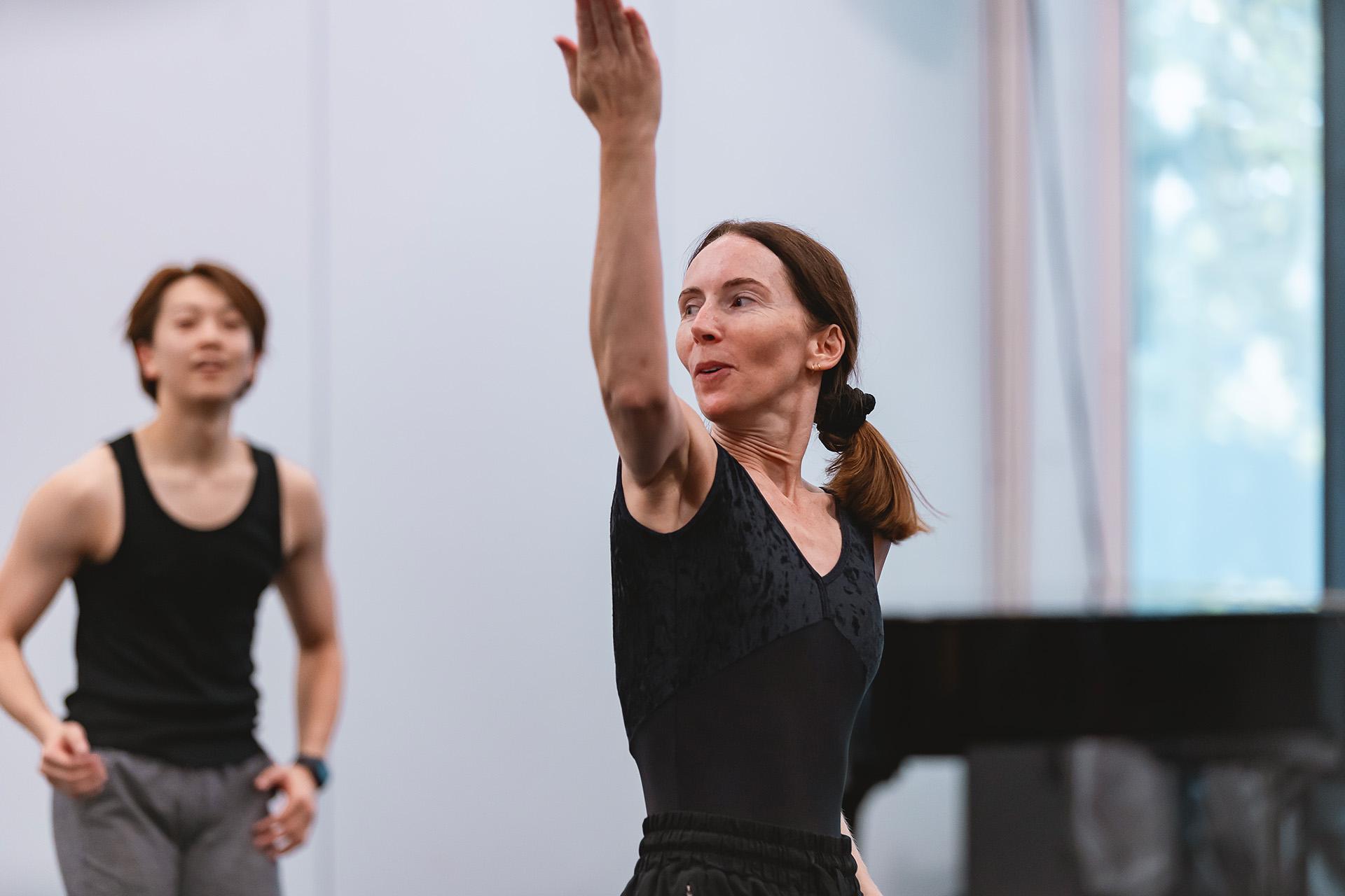 Choreographer Kristen MacNally demonstrates to the watching dancers the movements of the dance