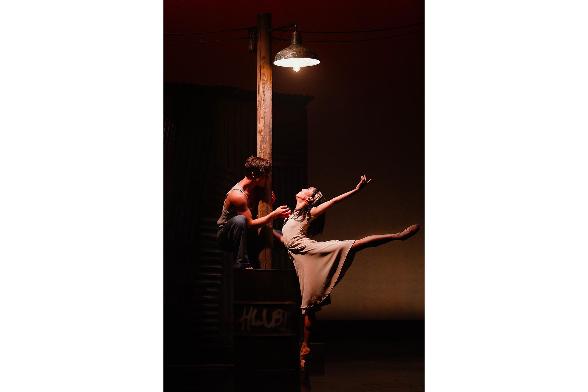 Two dancers underneath a lonely lamppost, dancing intimately in the weak light it casts