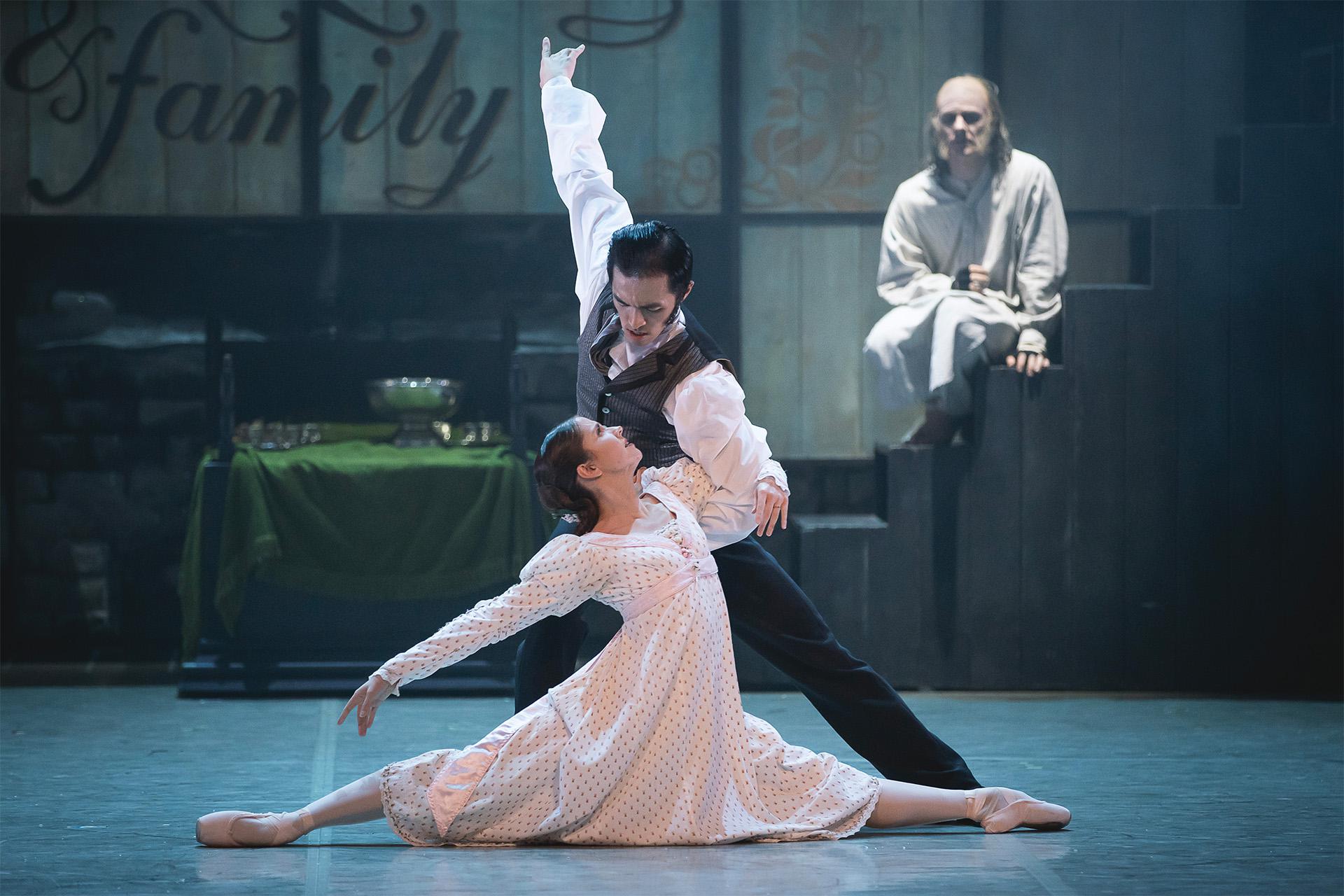 A Christmas Carol, 2024, production, dancer George Liang and Dominique Larose, photo Emily Nuttall Scrooge watches on from a step in the background as a Young Scrooge dancers with Belle in the foreground.