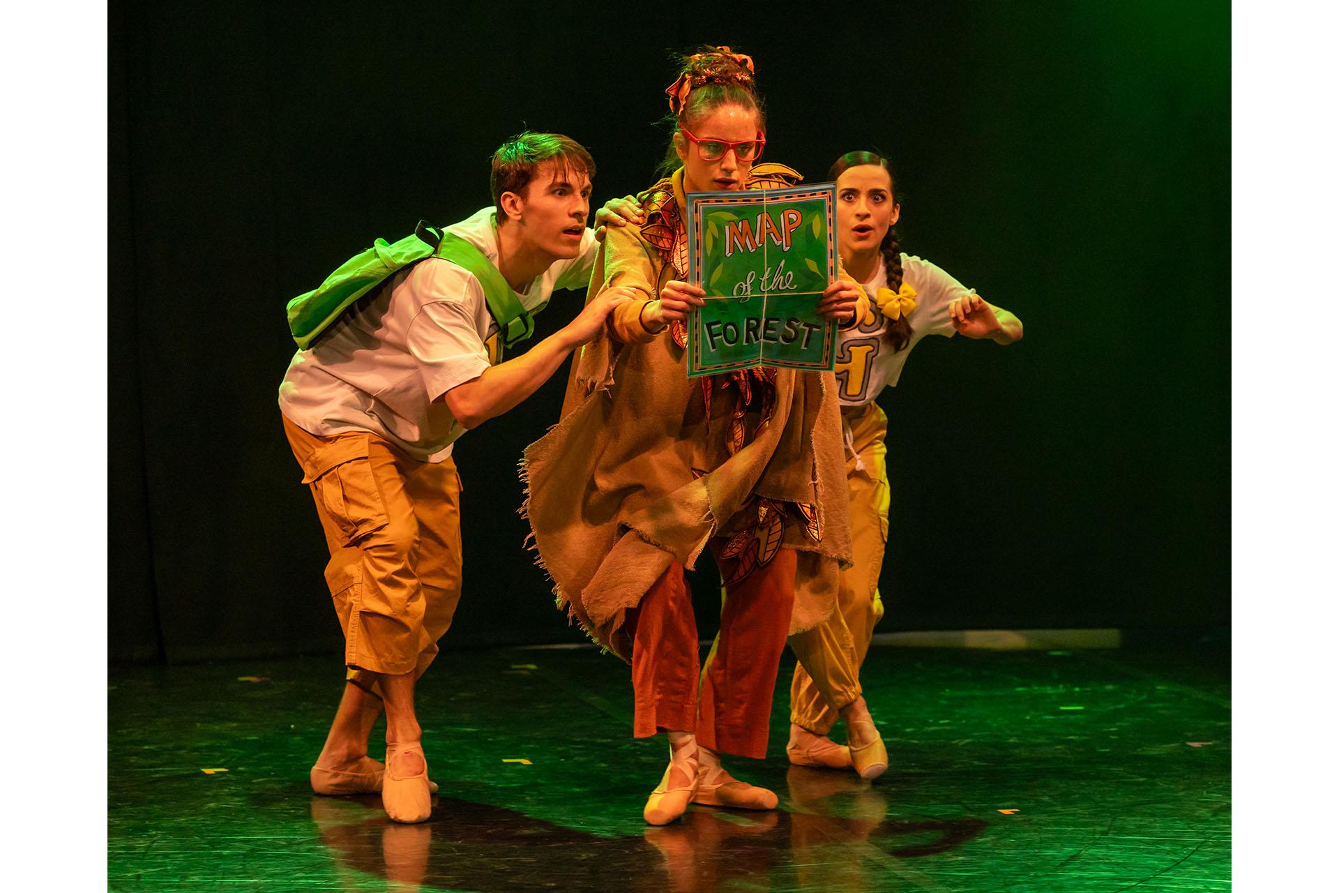 The Lady of the Forest holds the 'Map of the Forest' as she, Hansel and Gretel look at it.