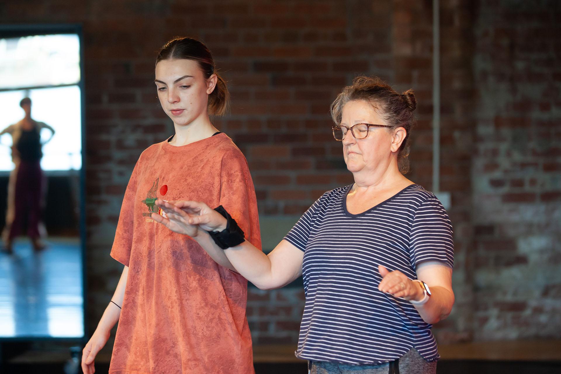 Learning, Expressions, Unbound Dance Theatre by Simon K. Allen Person wearing a horizontally striped top and eyes closed with a forearms lifted straight in front of her, her companion beside her supporting her left hand