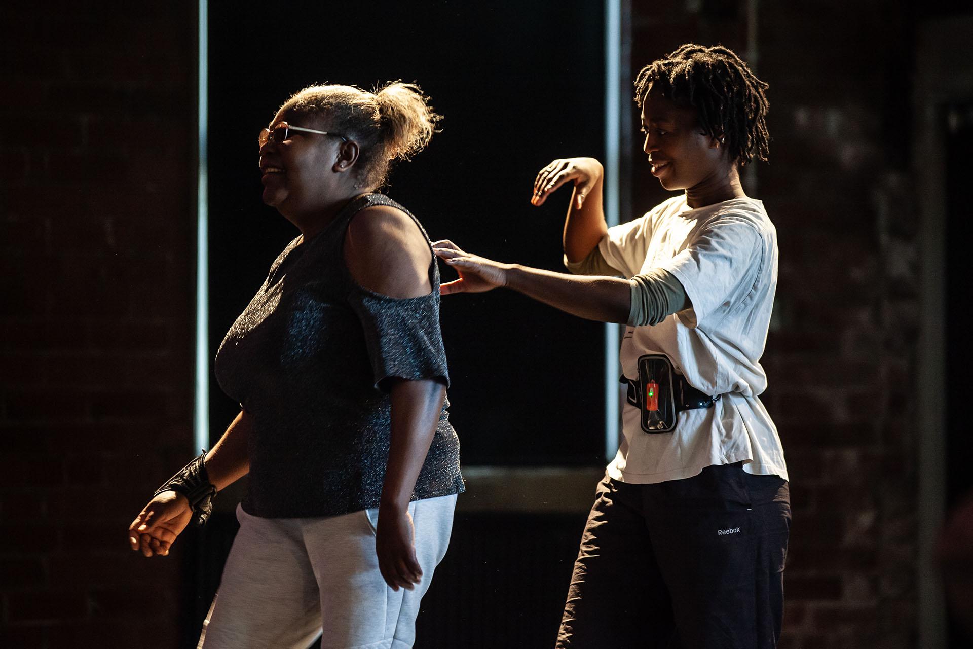 Learning, Expressions, Unbound Dance Theatre by Simon K. Allen One person in front of the other, the person behind guiding the other by placing the fingers of their left hand on her back