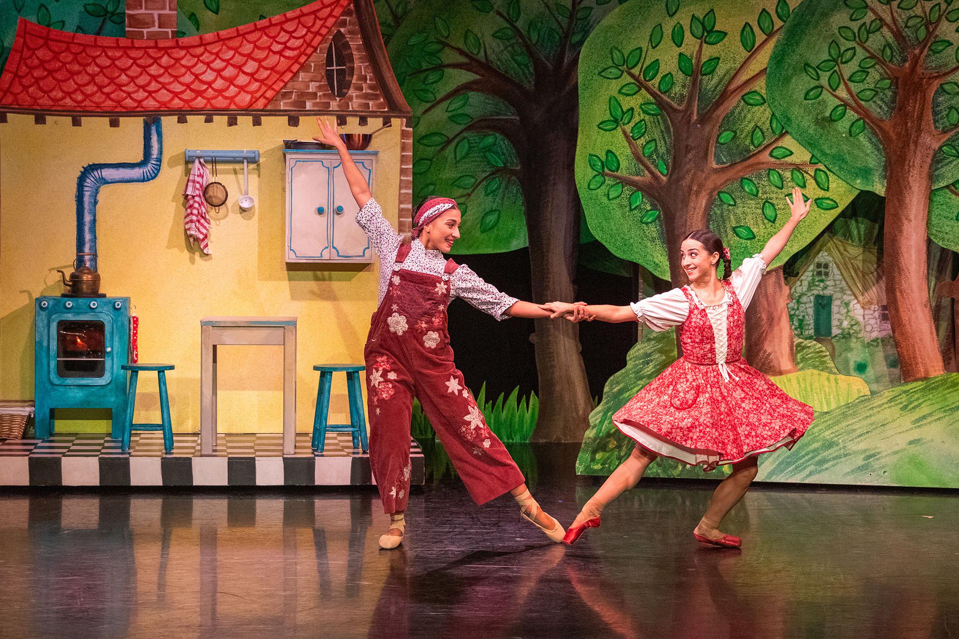 Little Red Riding Hood, production, 2025, dancers Alessia Petrosino and Julie Nunès. Photo Colleen Mair Little Red and her mother dancing in front of their yellow house by the forest