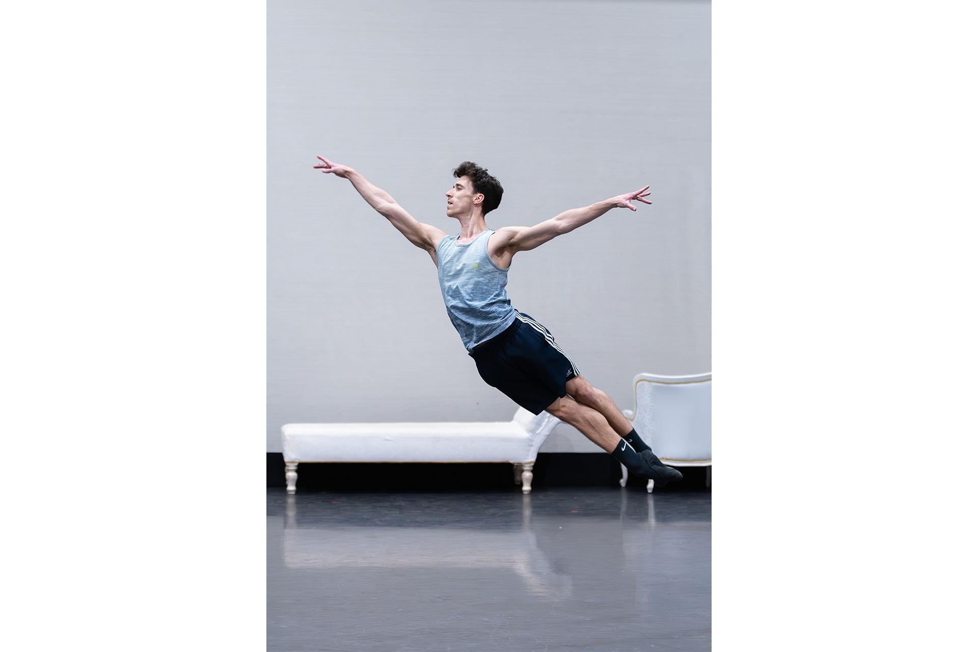 Dancer leaping through the air, arms raised, feet together