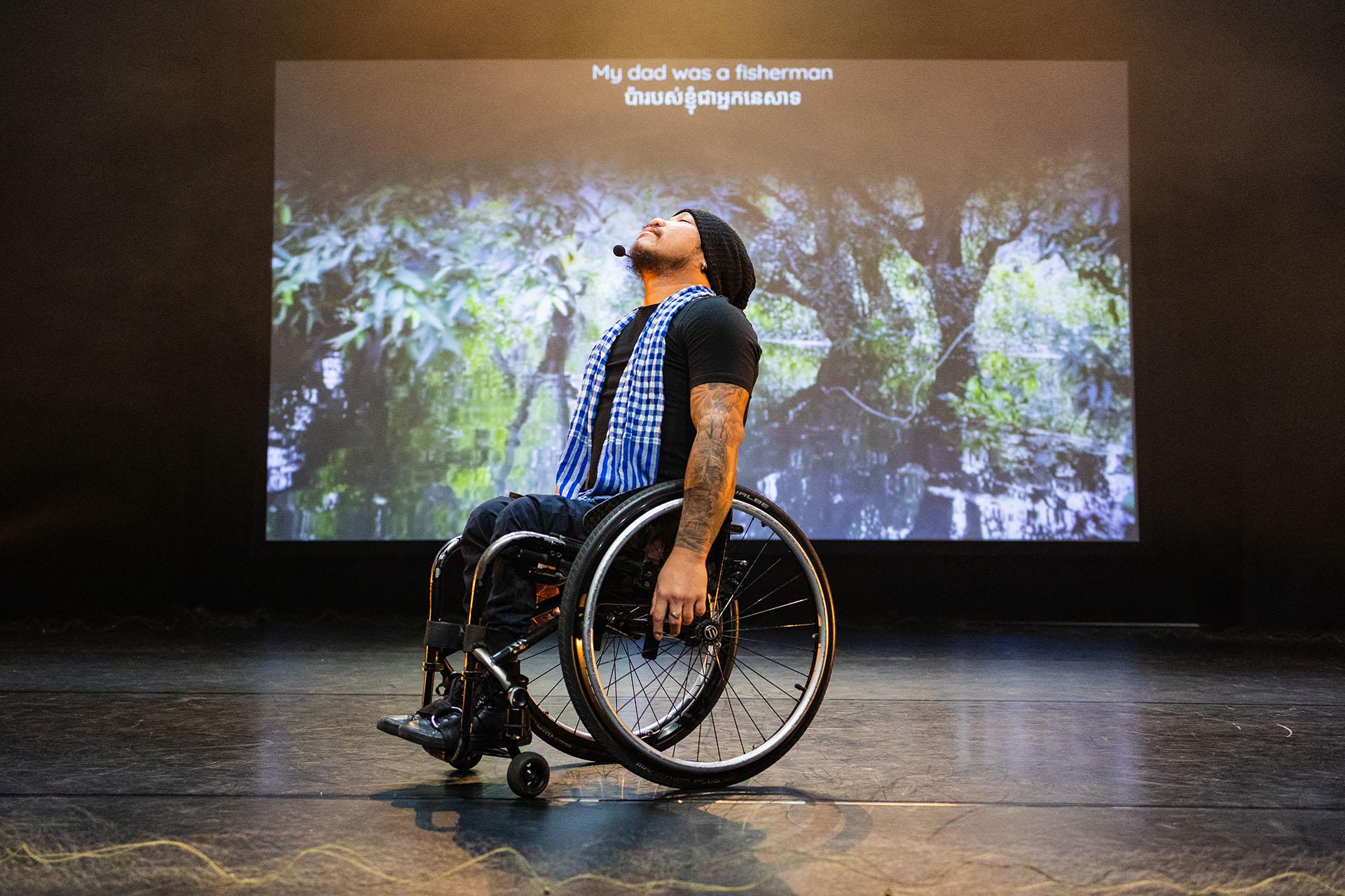 Man in a wheelchair, arms down, his face raised to the sky
