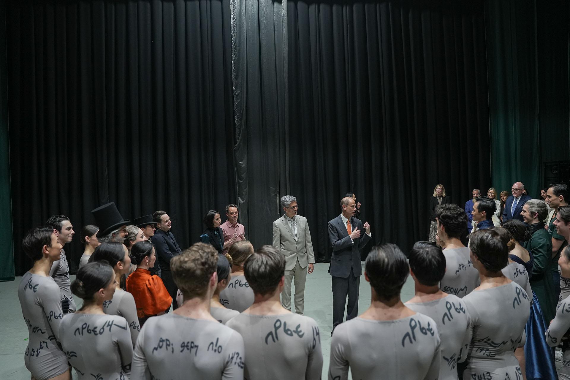 Northern Ballet dancers in a circle on stage meeting HRH The Duke of Edinburgh