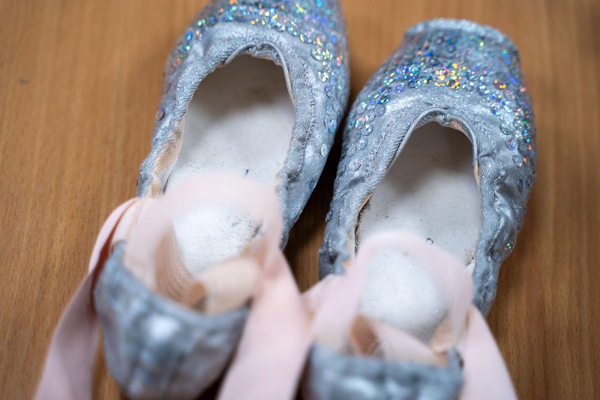 Silver pointe shoes decorated with sequins reflecting iridescent colours