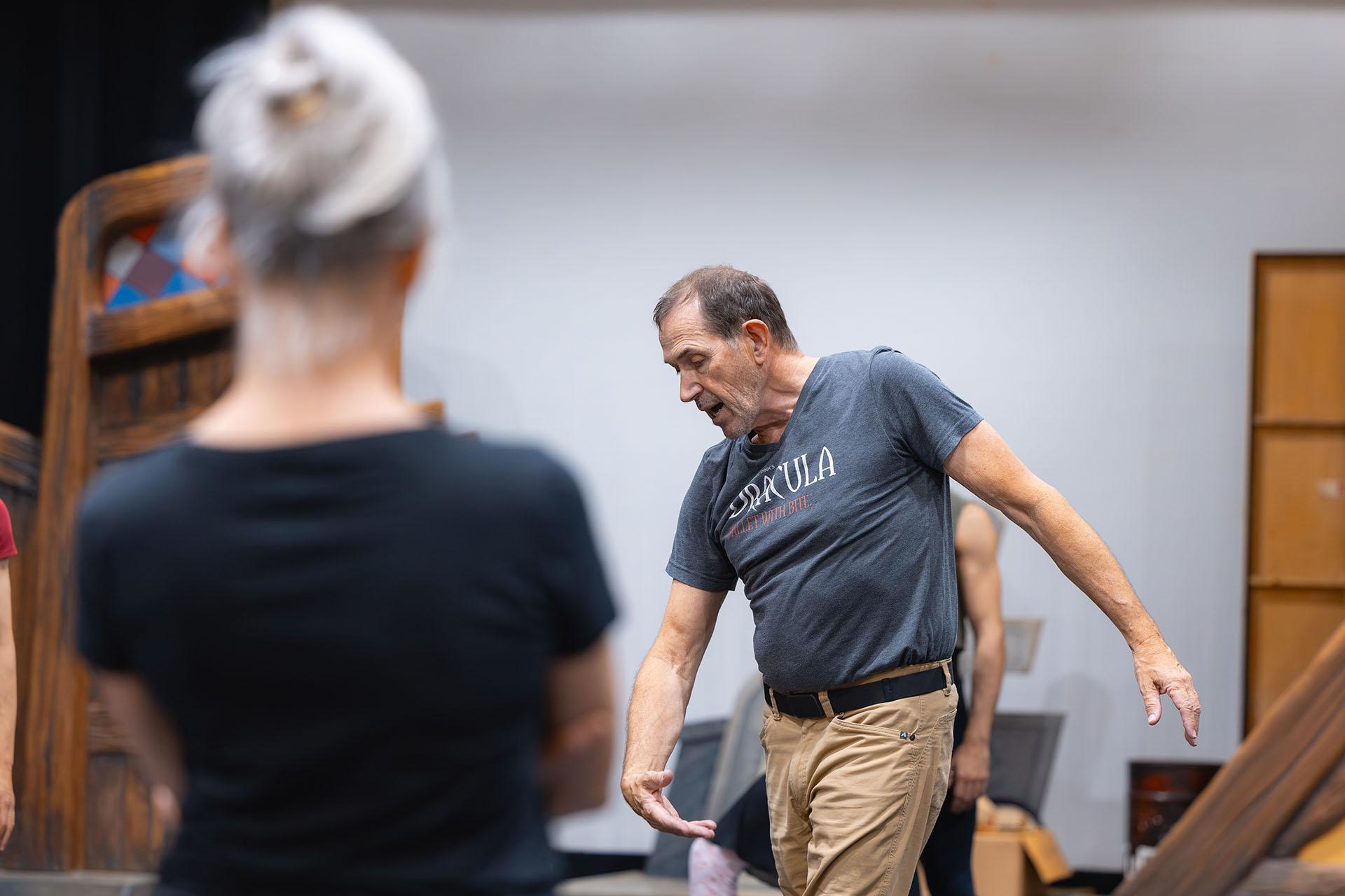 In the rehearsal studio the choreographer demonstrates the movements in front of the dancers