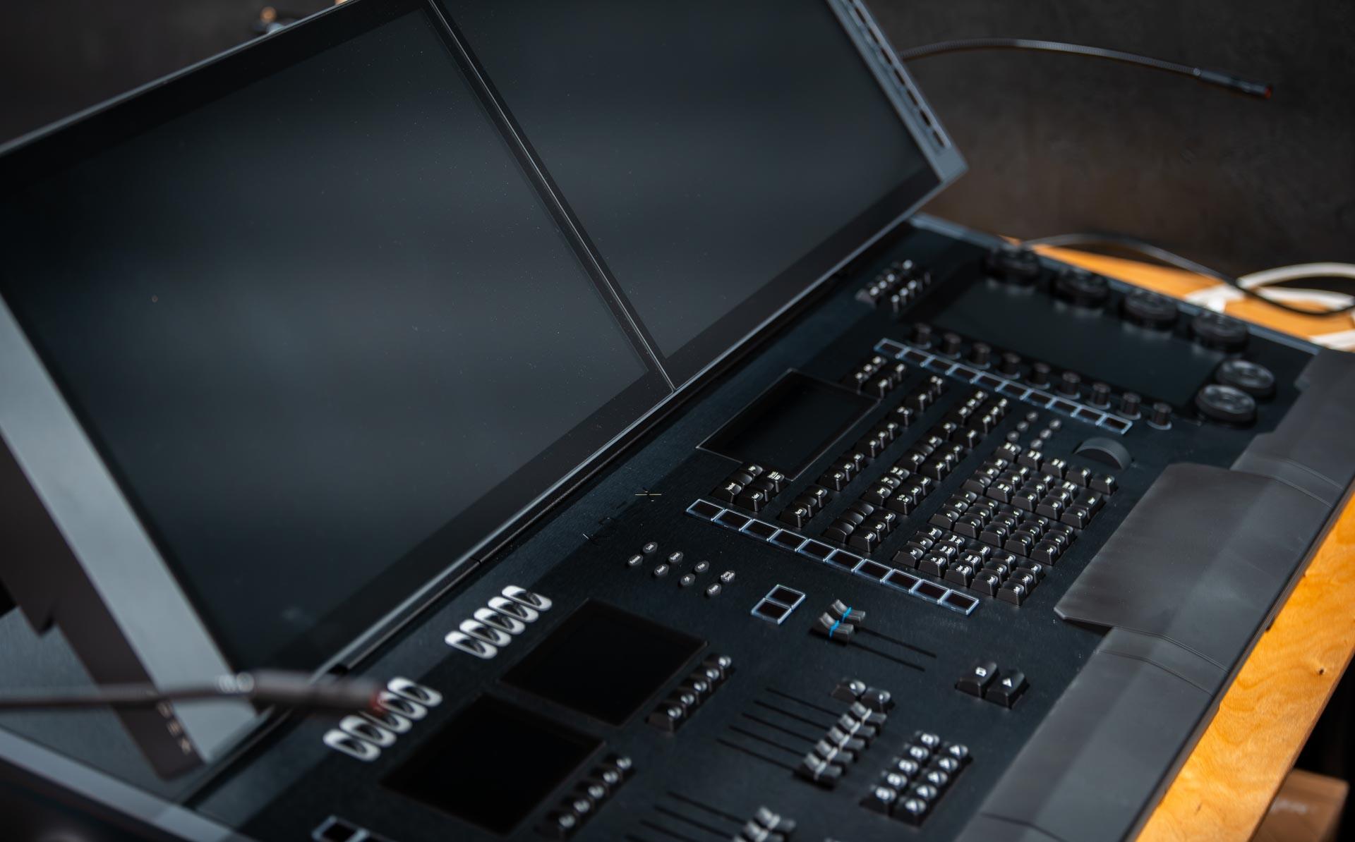 A zoomed in image of a black lighting desk with coloured buttons