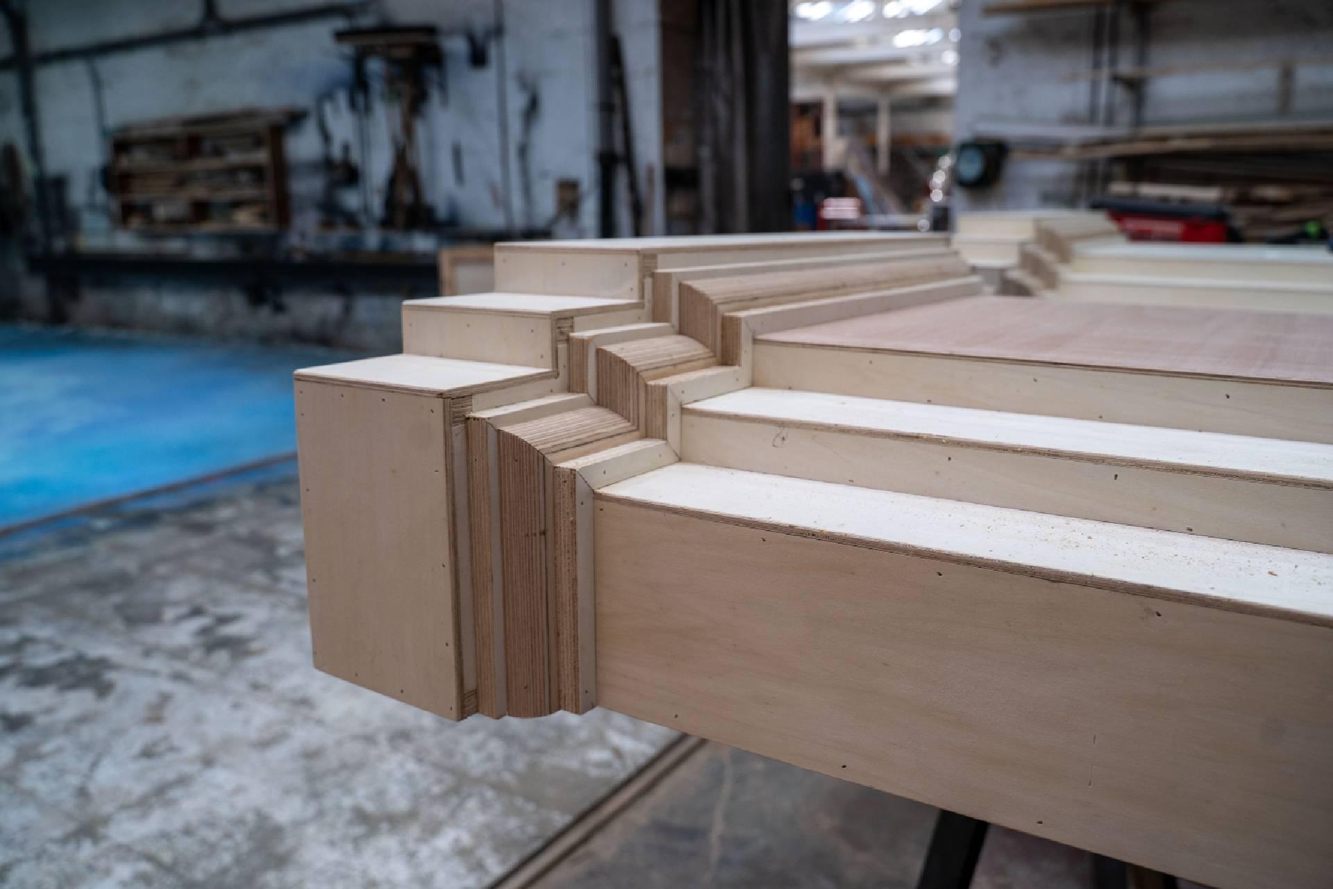 In a workshop, bare wooden columns are being built for the set of Swan Lake.
