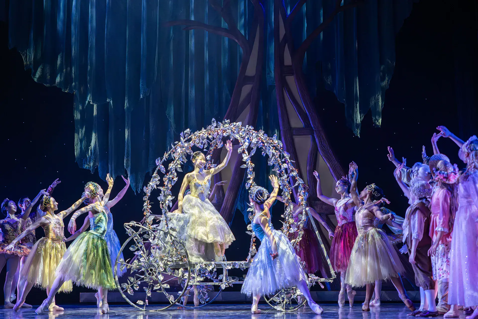 Cinderella waves from her crystal carriage at the crown of beautiful guests