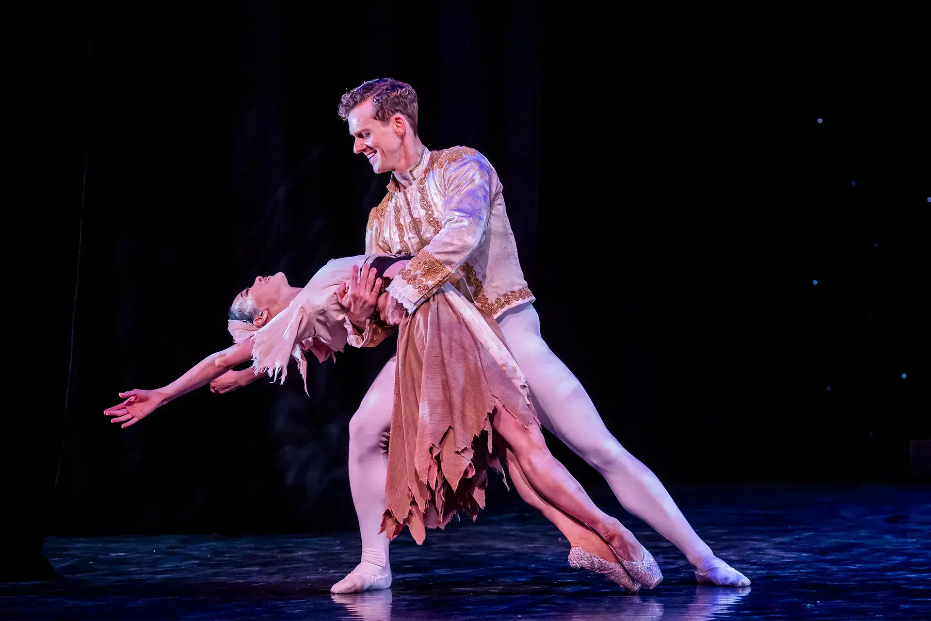 Cinderella leaning back supported at the waist by the smiling Prince