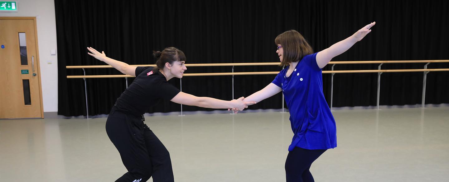 Two people dance in a studio