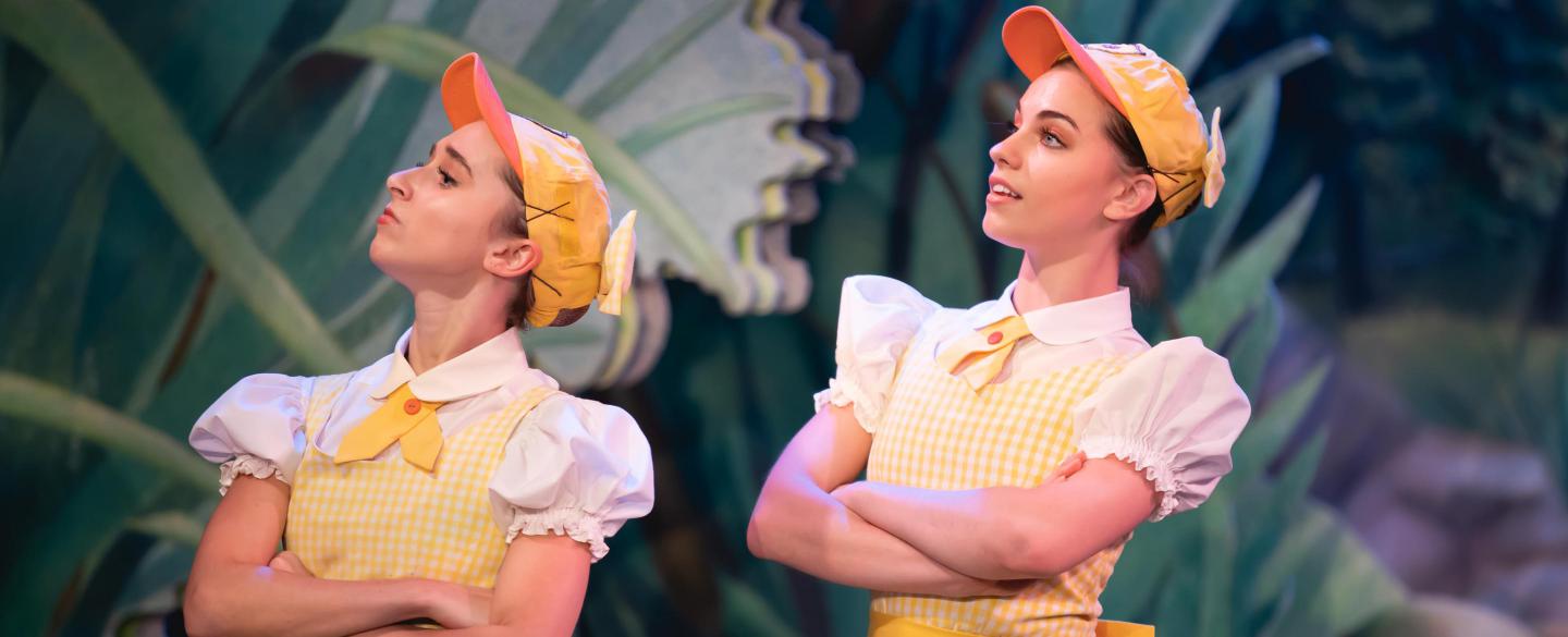 Two dancers in duckling costumes with arms folded