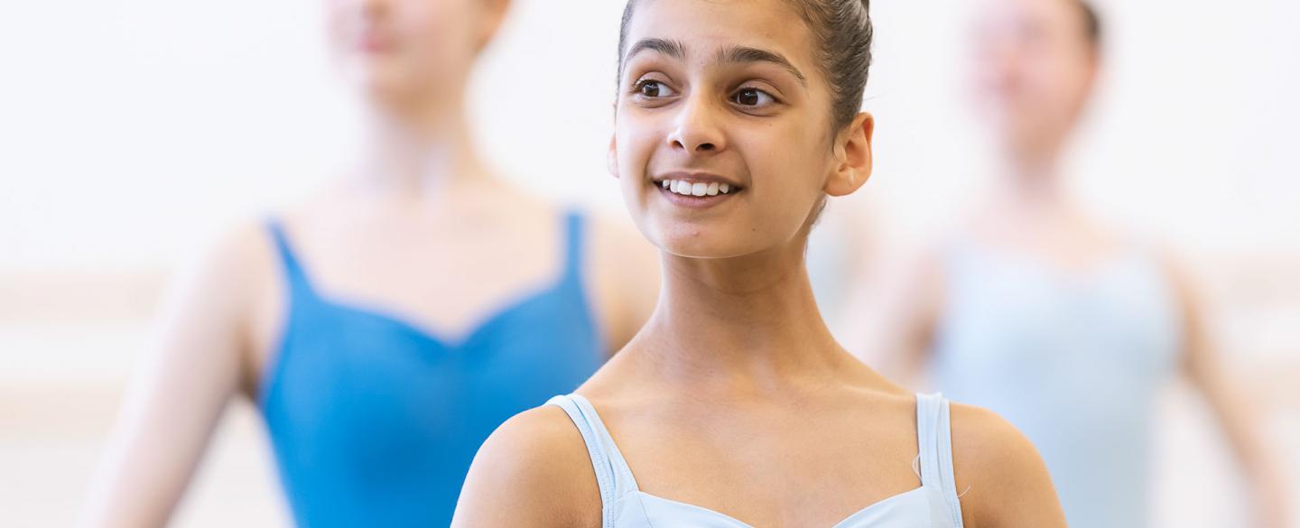 A young girl stood in ballet class