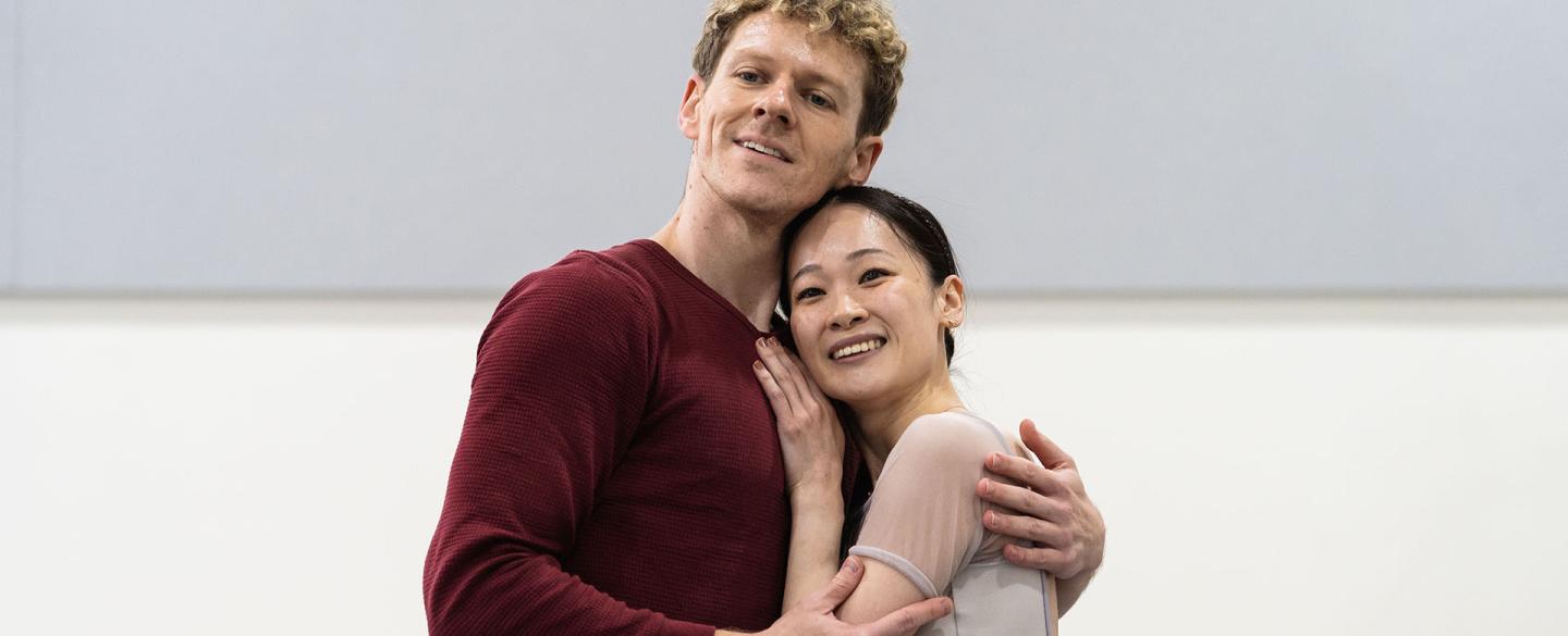 Two dancers hold each other lovingly and smile