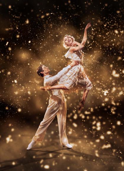 Gatsby hold Daisy aloft against a fantsy golden background