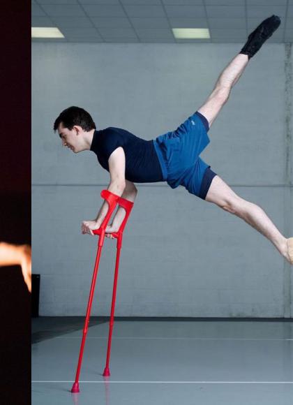Joseph is sat in a wheelchair with his arms stretched on the left, and on the right he is lifting himself up on red crutches with both his legs swung behind him.