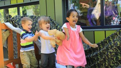 Three children looking excitedly off camera