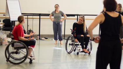 A group of people in a dance workshop, including two wheelchair users