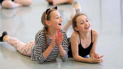 Two girls sat on the floor smiling