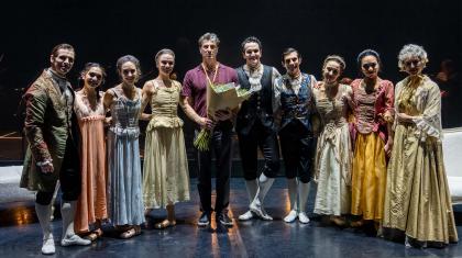 David stands with his dancers on stage as they pose to the camara