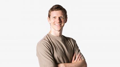 Headshot of a male dancer in a brown shirt