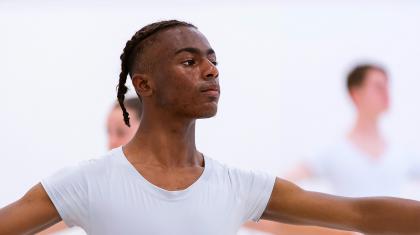Male Academy student in a white T-shirt with his arms outstretched