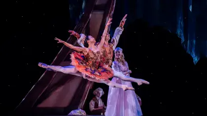 Leaping across the stage, dancers in their tutus, wearing poite shores and looking up